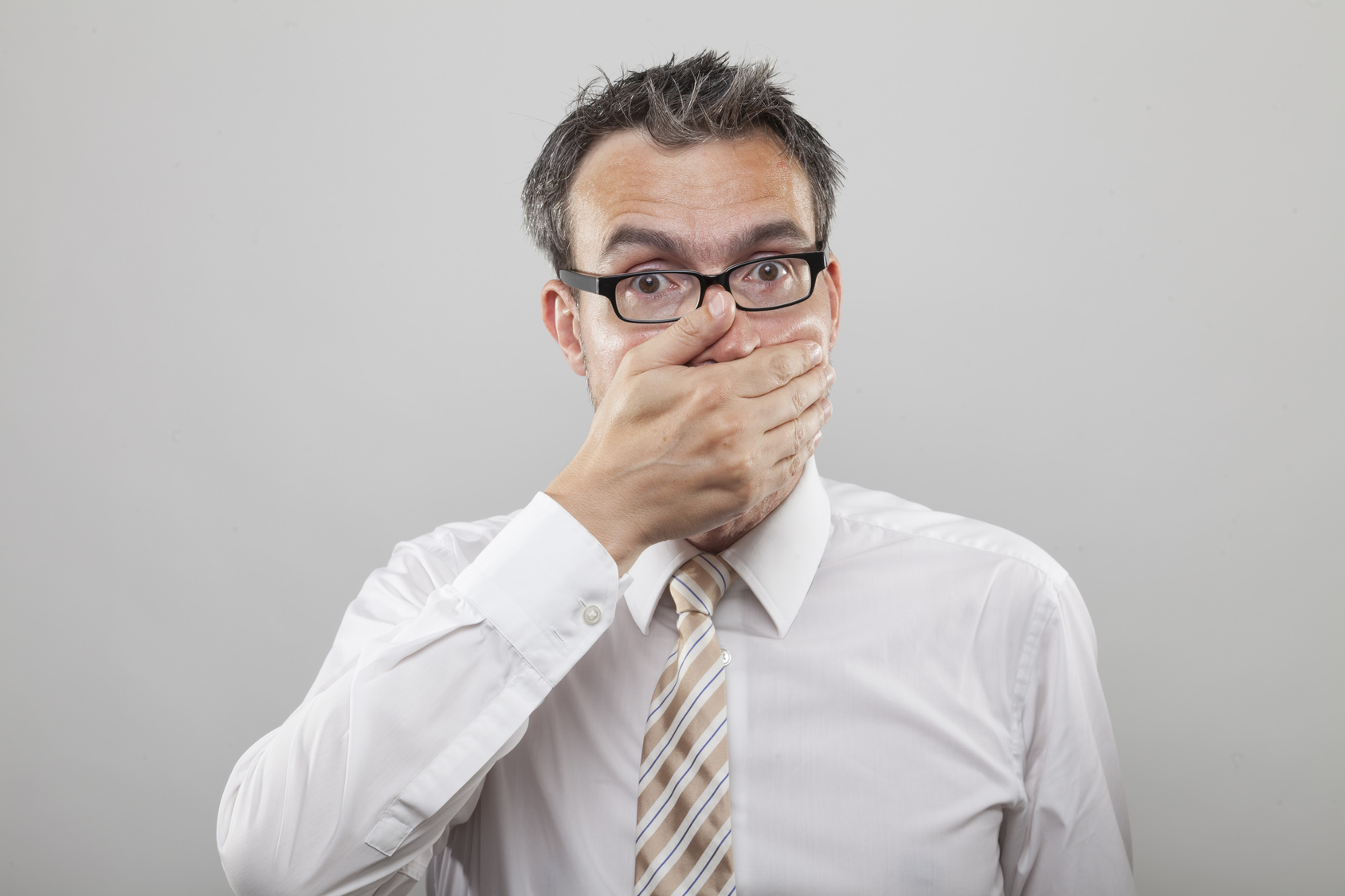 Man holds his hand to his mouth due to sickness or wrong decision